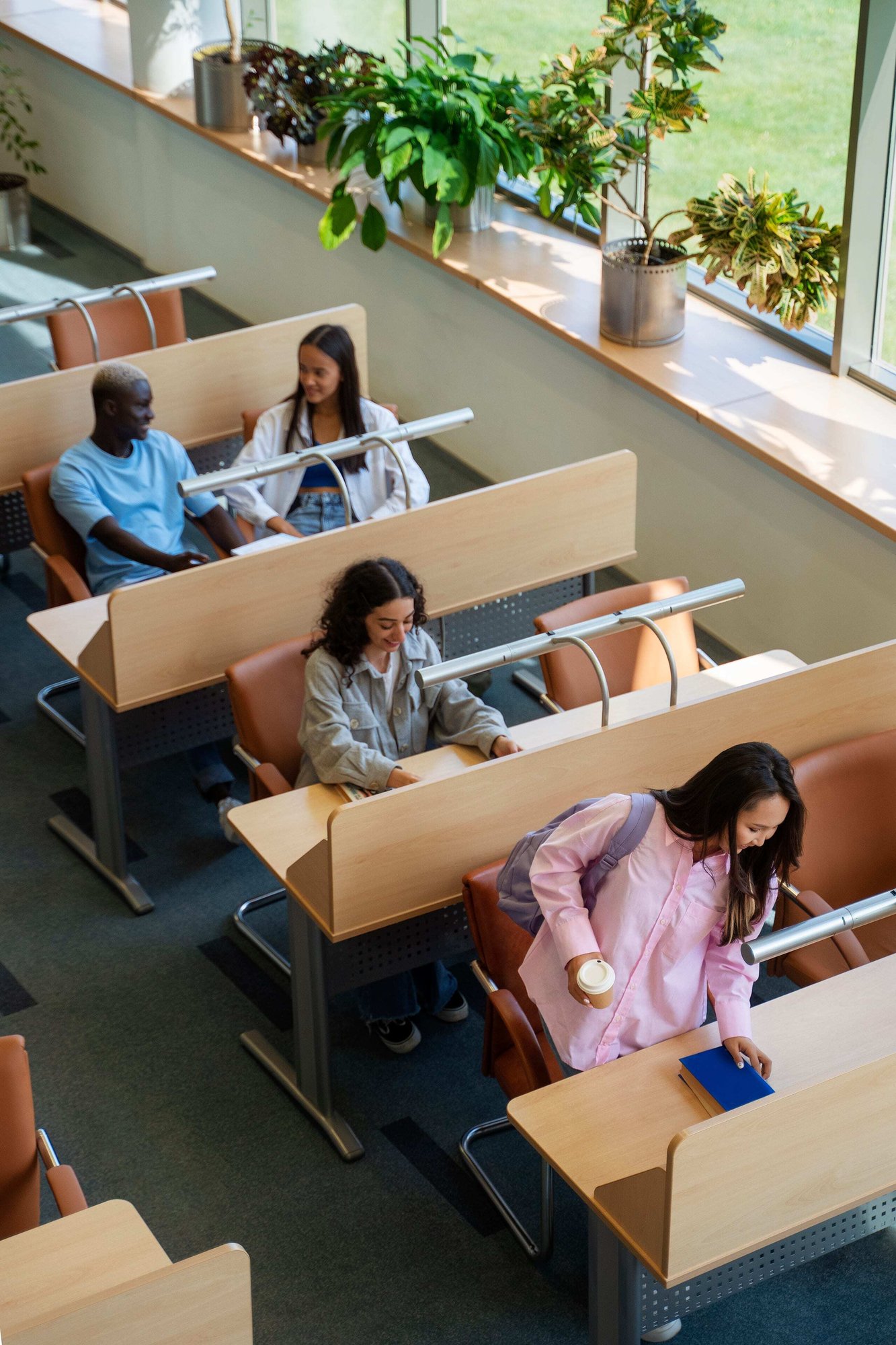 College students studying together around a shared table, viewed from above